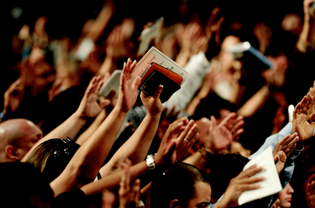 People worshiping with hands raised during Eagle Mountain gathering